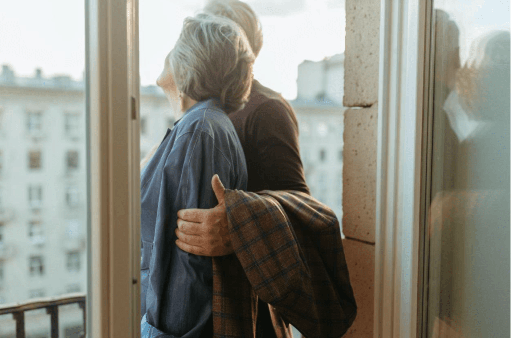 Older couple looking out over balcony.