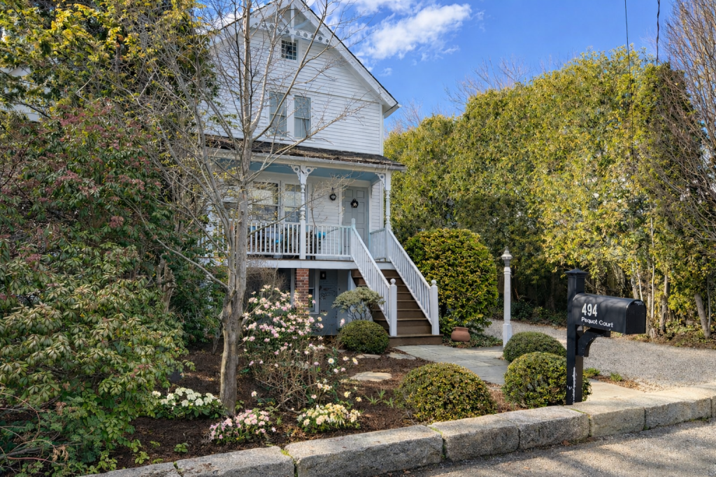 Photo of charming vintage antique home with delicate early spring garden and granite curbstones.